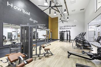 A gym with a variety of equipment including treadmills, weights, and exercise machines.